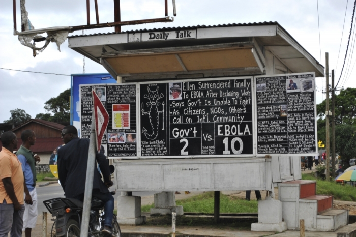 People read news of the Ebola virus epidemic at the Daily Talk, a street side news chalkboard in Monrovia, Liberia, September 25, 2014.