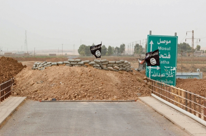 Islamic State flags flutter on the Mullah Abdullah bridge in southern Kirkuk September 29, 2014. Members of the Kurdish security forces and the Islamic State are holding fort behind sandbags on different ends of the bridge.