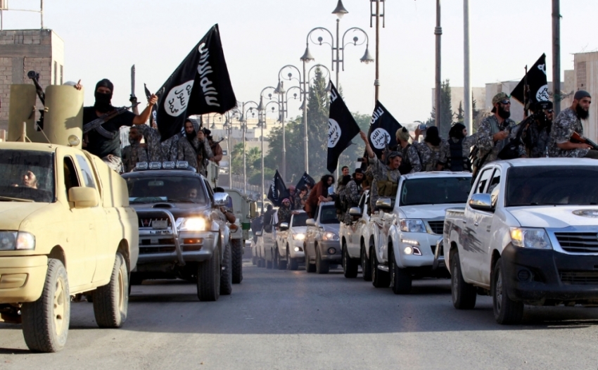 Militant Islamist fighters parade on military vehicles along the streets of northern Raqqa province, Syria, June 30, 2014. Militant Islamist fighters held a parade in Syria's northern Raqqa province to celebrate their declaration of an Islamic
