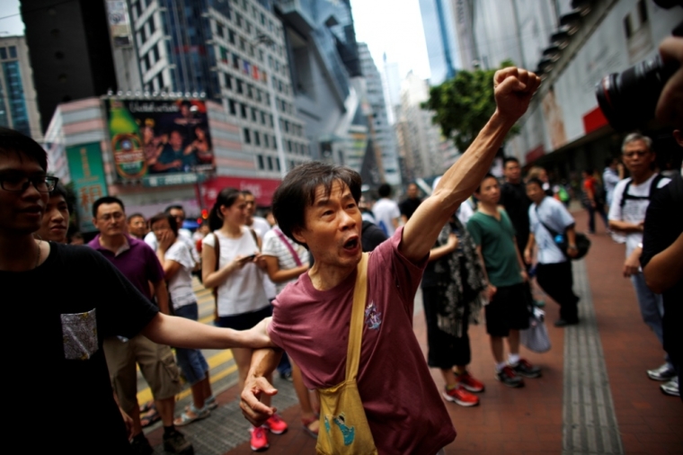 A pro-democracy protester argues with a pro-Beijing demonstrator (not pictured) as people block areas around the government headquarters building in Hong Kong, October 1, 2014. Thousands of pro-democracy protesters thronged the streets of Hong Kong early on Wednesday, ratcheting up pressure on the pro-Beijing government that has called the action illegal, with both sides marking uneasy National Day celebrations.