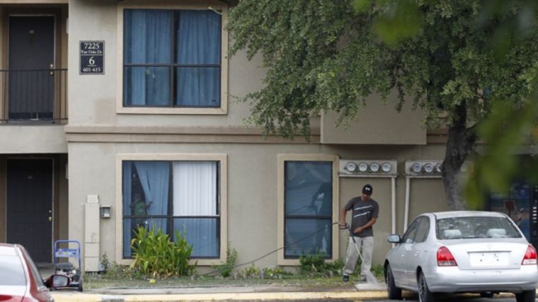 A worker power washes the sidewalk in front of the apartment unit at The Ivy Apartments where a man diagnosed with the Ebola virus was staying in Dallas, Texas October 2, 2014.