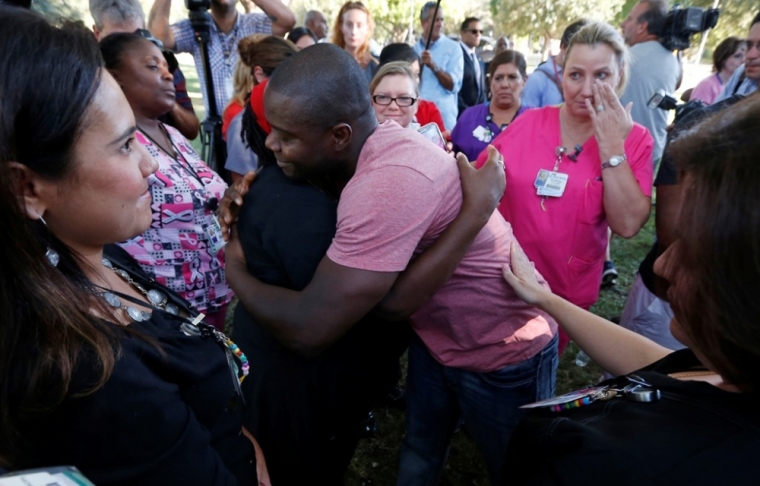 Josephus Weeks (R), nephew of Thomas Eric Duncan, the first patient diagnosed with Ebola on U.S. soil, gets a hug from a supporter at a prayer vigil for his uncle in Dallas, Texas, October 7, 2014. Duncan, who was in critical condition and on a ventilator and kidney dialysis, died at Texas Health Presbyterian Hospital in Dallas, Wednesday, October 8, 2014.