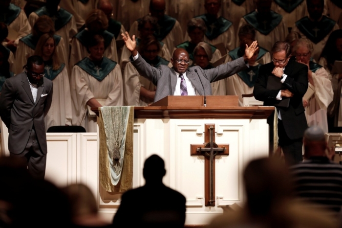 Bishop Nathan Kortu (L) of New Life Fellowship Church leads parishioners in prayer during a vigil for Thomas Eric Duncan at Wilshire Baptist Church in Dallas, Texas, October 8, 2014. The first person diagnosed with Ebola in the United States, Liberian national Thomas Eric Duncan, died Wednesday morning, a hospital spokesman said.