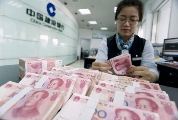 A clerk counts Chinese 100 yuan banknotes at a branch of China Construction Bank in Hai.