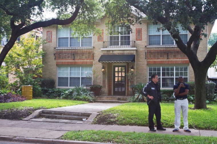 A Dallas police officer and a Dallas Fire Department Community officer, Shawn Williams (R) stand in front of the residence of a health worker at the Texas Health Presbyterian Hospital who has contracted Ebola in Dallas, Texas, October 12, 2014. The infected worker, identified as a woman but not named by authorities as they announced the case on Sunday, is believed to be the first person to contract the disease in the United States.