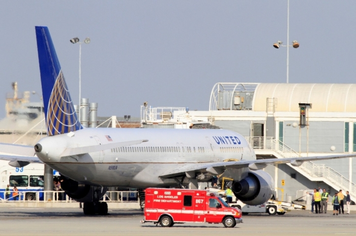 A Los Angeles Fire Department Paramedic truck drives past a United Airlines plane from New York's JFK airport, that was diverted to a remote gate after landing at LAX, after a passenger on the flight exhibited flu-like symptoms, in Los Angeles, California, October 12, 2014. The passenger was later determined not be an Ebola threat after it was learned the passenger had been in South Africa, according to a Los Angeles Fire Department spokesman.