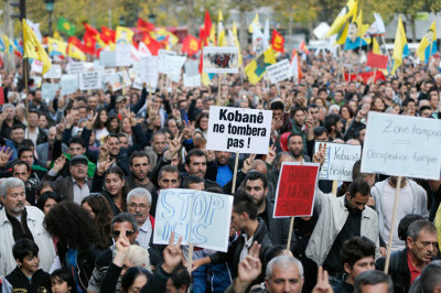 Members of the Kurdish community in France shout slogans during a demonstration against the Islamic State and to bring attention to the plight of Kurds in the Syrian town of Kobani, during a march in Paris October 11, 2014. The sign (C) reads, 'Kobane will not fall'.