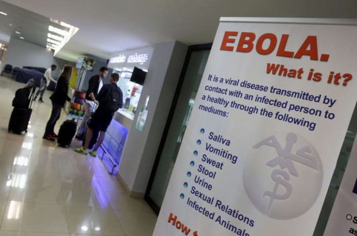 An sign explaining the symptoms of Ebola stands inside a hall for arriving passengers at the international airport in Guatemala City, October 13, 2014. Guatemala has stepped up caution and security measures at the airport to prevent an Ebola outbreak, according to local media.
