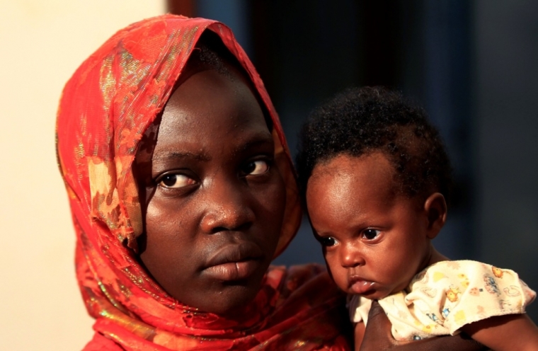 Ishtyyag, 11, holds a 4-month-old baby girl whom she says is her child, is pictured inside the Center for Training and Protection of Women and Child's Rights in Khartoum, Sudan, October 12, 2014. Ishtyyag was married when she was 10 and is now divorced.