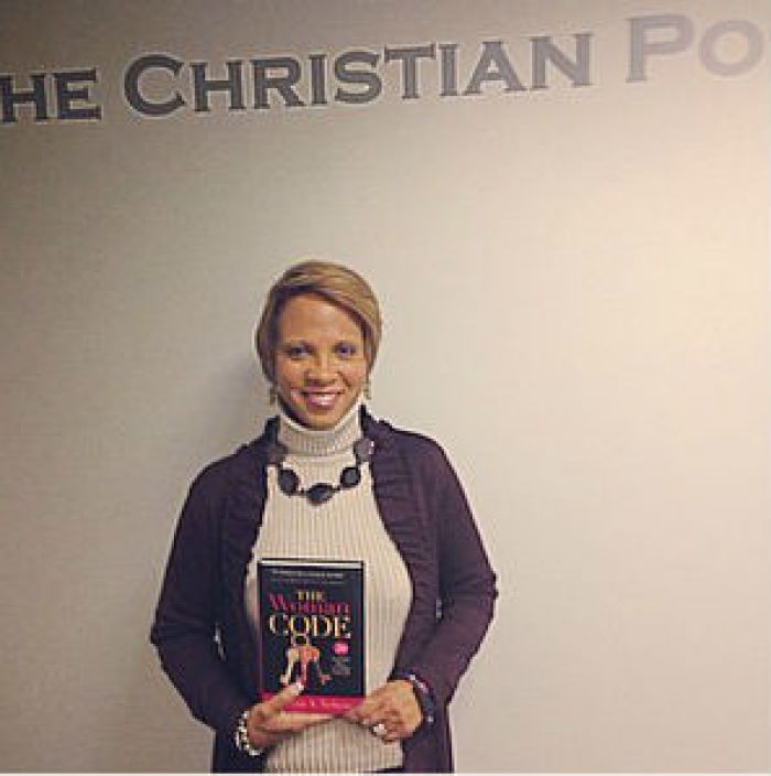 Sophia A. Nelson, Esq. holds a copy of her book 'The Woman Code: 20 Powerful Keys To Unlock Your Life'