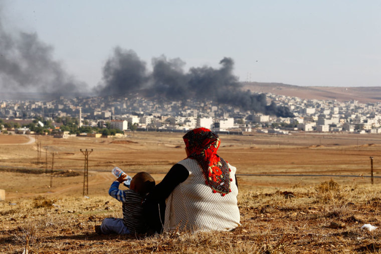 DATE IMPORTED:October 18, 2014Turkish Kurds watch smoke rises over Syrian town of Kobani after an airstrike, as seen from the Mursitpinar border crossing on the Turkish-Syrian border in the southeastern town of Suruc in Sanliurfa province, October 18, 2014.