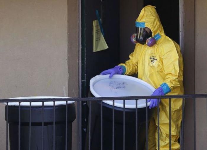 A worker in a hazardous material suit removes the contents of the apartment unit where a man diagnosed with the Ebola virus was staying in Dallas, Texas, October 6, 2014.