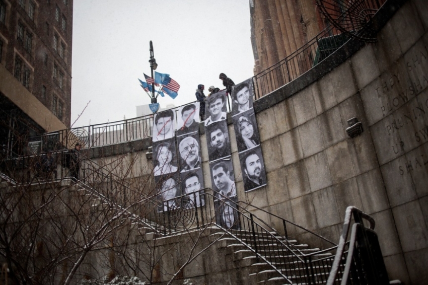 Members of Inside Out Group Action hang an installation outside of the United Nations Headquarters in New York, February 18, 2014. The installation is part of a global participatory art project started by famed street artist and 2011 TED prize winner JR, and features the portraits of 13 Iranian "prisoners of rights."