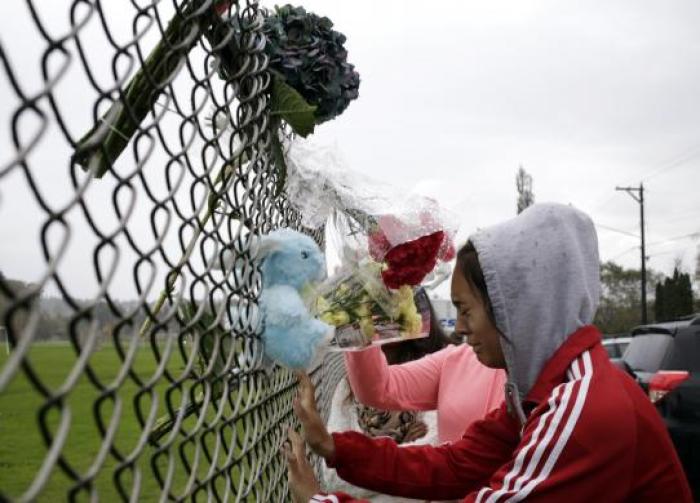Student Tyanna Davis cries after placing flowers on a fence outside Marysville-Pilchuck High School the day after a shooting at the school in Marysville, Washington October 25, 2014.