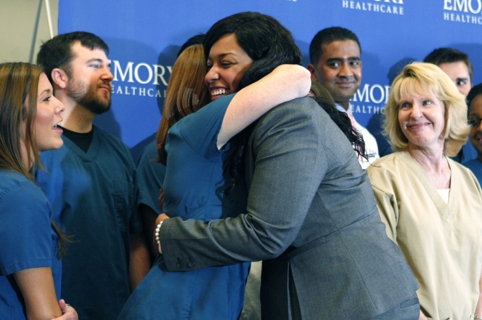 Amber Vinson hugs caregivers before her release from Emory University Hospital in Atlanta, Georgia, October 28, 2014. Vinson, 29, the second of two American nurses who became infected with Ebola while treating a Liberian man who died of the disease in Texas was released from an Atlanta hospital on Tuesday having been declared free of the virus.