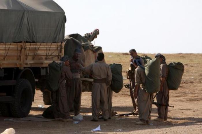Kurdish peshmerga fighters prepare before leaving their base on the outskirts of Arbil in northern Iraq, on their way to the Syrian town of Kobani, October 28, 2014.