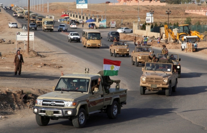 A convoy of Kurdish peshmerga fighters drive through Arbil after leaving a base in northern Iraq, on their way to the Syrian town of Kobani, October 28, 2014.