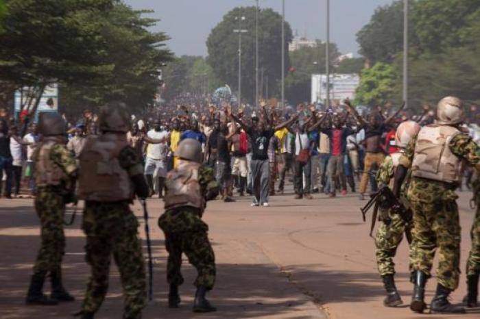 Soldiers attempt to stop anti-government protesters from entering the parliament building in Ouagadougou, capital of Burkina Faso, October 30, 2014.