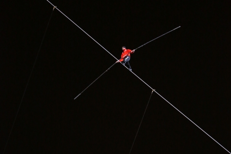 Daredevil Nik Wallenda walks along a tightrope between two skyscrapers suspended 500 feet (152.4 meters) above the Chicago River in Chicago, Illinois, November 2, 2014.