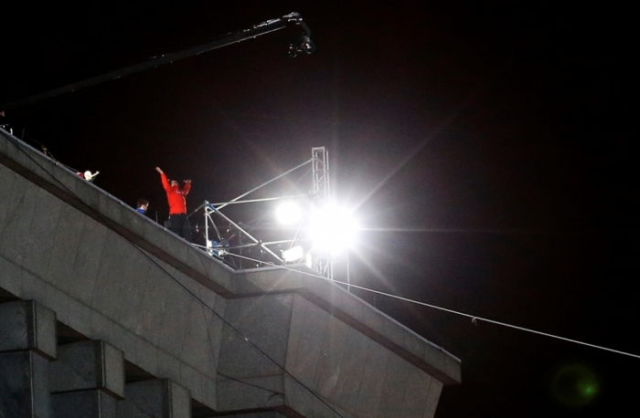 Daredevil Nik Wallenda reacts after completing his first walk along a tightrope between two skyscrapers suspended 500 feet (152.4 meters) above the Chicago River in Chicago, Illinois, November 2, 2014.
