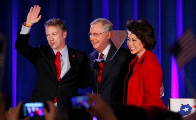 U.S. Republican Senator Rand Paul from Kentucky (L) waves with Senate Minority Leader Mitch McConnell, R-Ky., and McConnell's wife, former United States Secretary of Labor Elaine Chao, at McConnell's midterm election night victory rally in Louisville, Kentucky, November 4, 2014.