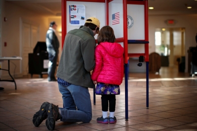 Kieran Campion kneels with his daughter Cordelia, 5, as he fills out his ballot to vote at the Presbyterian Church in the town of Mount Kisco, New York, November, 4, 2014.