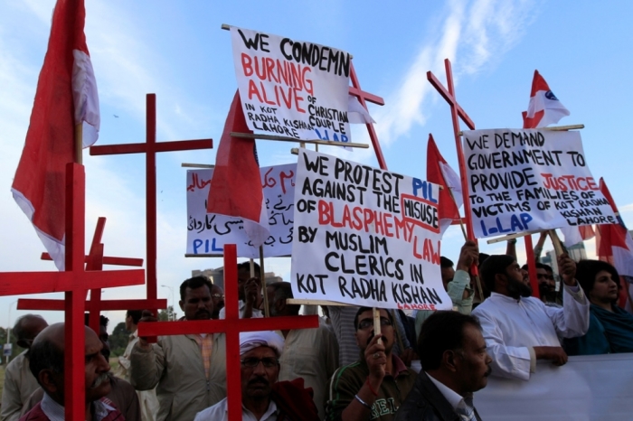 Members of the Pakistani Christian community hold placards and wooden crosses during a demonstration to condemn the death of a Christian couple in a village in Punjab province on Tuesday, in Islamabad, November 5, 2014. Police in Pakistan arrested dozens of people on Wednesday after a mob beat a Christian couple to death and burned their bodies for allegedly desecrating a Koran.