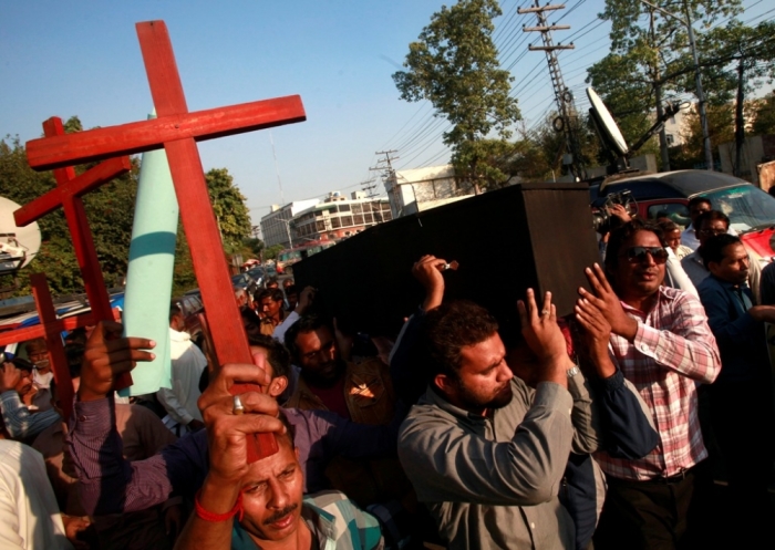 Members of the Pakistani Christian community carry wooden crosses and a casket during a demonstration to condemn the death of a Christian couple in a village in Punjab province on Tuesday, in Lahore, November 5, 2014. Police in Pakistan arrested dozens of people on Wednesday after a mob beat a Christian couple to death and burned their bodies for allegedly desecrating a Koran.