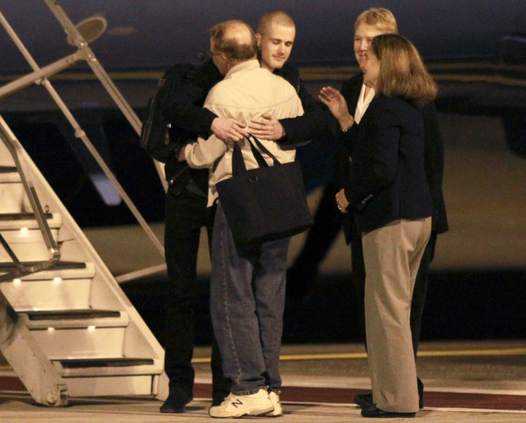 Matthew Todd Miller (C, facing camera) reunites with his family members after he and Kenneth Bae (not pictured) landed aboard a U.S. Air Force jet at McChord Field at Joint Base Lewis-McChord, Washington November 8, 2014. Two Americans, Bae and Miller, freed from secretive North Korea returned home on Saturday after the surprise involvement of the top-ranking U.S. intelligence official who traveled to Pyongyang to secure their release. Miller, who reportedly was tried on an espionage charge, had been in custody since April this year and was serving a six-year hard labor sentence.