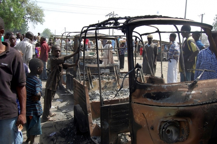 Residents survey vehicles damaged after a bomb blast at a primary school in Maiduguri, the capital of Nigeria's Borno state, February 29, 2012.