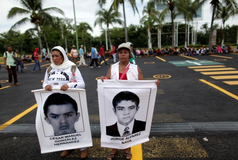 Relatives hold photographs of trainee teachers on the parking lot of the airport during a protest in reprisal for the apparent killing of 43 trainee teachers, in Acapulco, November 10, 2014. According to the government, corrupt police in league with a local drug gang abducted and apparently murdered the students in the southwestern sate of Guerrero in late September. The government says it found charred remains of dozens of bodies in a garbage dump and in a river, and that three men detained in the case admitted setting fire to the victims.