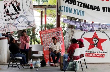 Relatives of missing students sit next to a banner reading "they took them alive, we want them back alive" outside their Ayotzinapa Teacher Training College in Tixtla, near Chilpancingo, in the southwestern state of Guerrero, November 10, 2014. The students were abducted by corrupt police in September. Though the government said on Friday it looked as though the students had been killed, then incinerated by gangsters working with the police, it stopped short of confirming their deaths for lack of definitive evidence.