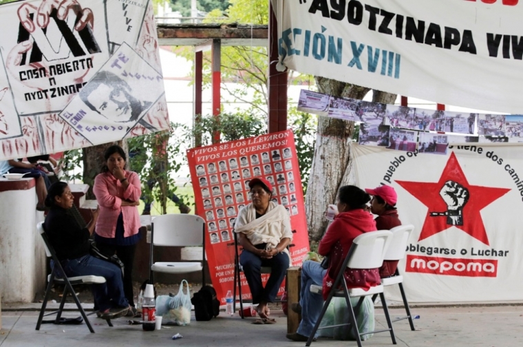Relatives of missing students sit next to a banner reading 'they took them alive, we want them back alive' outside their Ayotzinapa Teacher Training College in Tixtla, near Chilpancingo, in the southwestern state of Guerrero, November 10, 2014. The students were abducted by corrupt police in September. Though the government said on Friday it looked as though the students had been killed, then incinerated by gangsters working with the police, it stopped short of confirming their deaths for lack of definitive evidence.