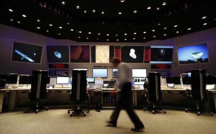 Scientists and mission control workers check their monitors at the European Space Agency's (ESA) main control room in Darmstadt, August 6, 2014.