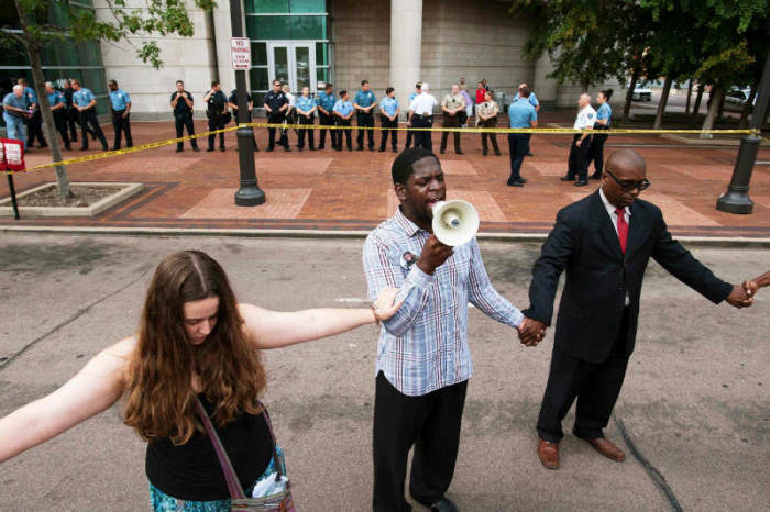 Demonstrators pray for justice outside the St. Louis County Justice Building in Clayton, Missouri, where a grand jury was convened to consider if charges were warranted against police officer Darren Wilson for fatally shooting Michael Brown.
