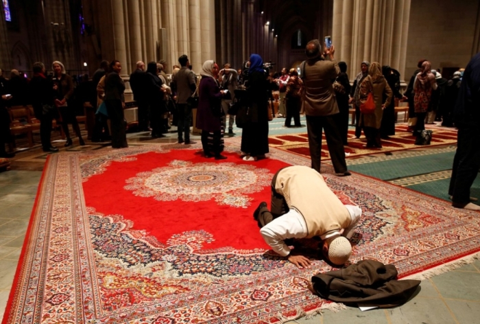 Omar Abdul-Malik prays alone as the Washington National Cathedral and five Muslim groups hold the first celebration of Muslim Friday prayers, Jumaa, in the cathedral's north transept in Washington, November 14, 2014.