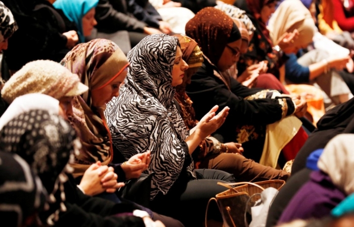 Women pray as the Washington National Cathedral and five Muslim groups hold the first celebration of Muslim Friday prayers, Jumaa, in the cathedral's north transept in Washington, November 14, 2014.