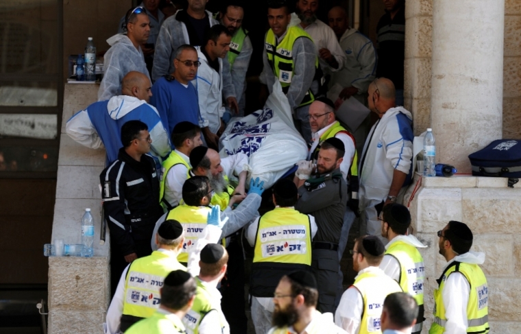 Israeli emergency personnel carry the body of a victim from the scene of an attack at a Jerusalem synagogue, November 18, 2014. Two suspected Palestinian men armed with axes and knives killed four people in a Jerusalem synagogue on Tuesday before being shot dead by police, Israeli police and emergency services said, the deadliest such attack in the city in years.