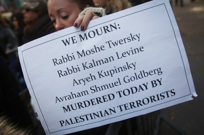 A woman holds a sign during a demonstration against a deadly attack on a Jerusalem synagogue, across the street from the Palestine Mission to the United Nations in New York November 18, 2014. Two Palestinian men armed with meat cleavers and a gun entered the synagogue in a quiet ultra-Orthodox neighborhood during morning prayers on Tuesday and attacked around 25 worshippers, killing four and wounding eight, several seriously. Three of the victims held dual U.S.-Israeli citizenship.