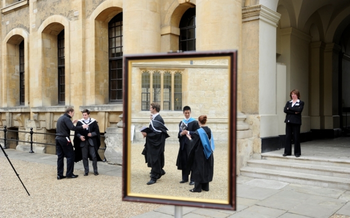 Graduates are seen queueing to have their photograph taken after a graduation ceremony at Oxford University, Oxford, southern England in this May 28, 2011 file photograph. Not much separates Britain's two oldest universities, Oxford and Cambridge, in their academic standing or the tally of victories in their annual boat race, but when it comes to finances, Cambridge is ahead by several lengths.