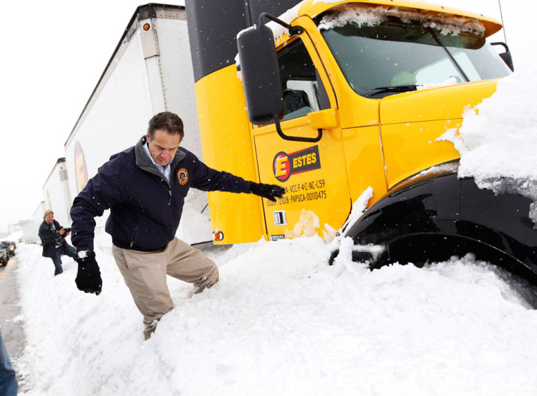 New York Governor Andrew Cuomo climbs over snow piled on the highway after talking with a stranded trucker on interstate I-190 while surveying an area in West Seneca.
