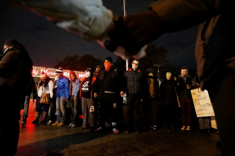 Protesters hold hands in prayer outside the Ferguson Police Department in Ferguson, Missouri, November 24, 2014. A Missouri grand jury has made a decision on whether to indict a white police officer in the fatal shooting of an unarmed black teenager in Ferguson, a killing that sparked angry protests in the St. Louis suburb, the Washington Post reported on Monday.