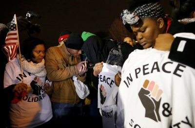 Protesters listen to the grand jury announcement in the shooting of Michael Brown outside the Ferguson Police Department in Ferguson, Missouri, November 24, 2014. Missouri Governor Jay Nixon urged people in the St. Louis area to show respect and restraint following a grand jury's decision on whether to criminally charge a white police officer in the August fatal shooting of unarmed black teenager Michael Brown.