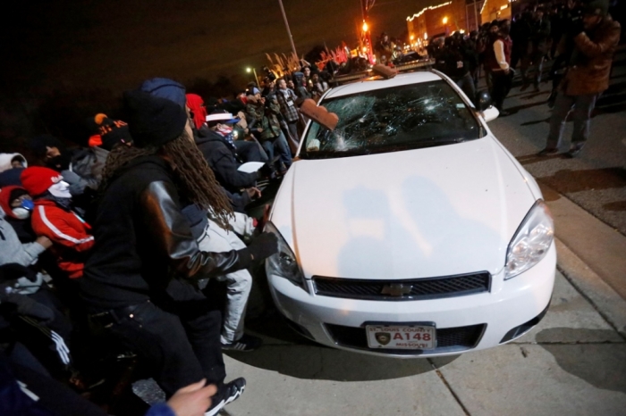 Protesters vandalize a police car outside the Ferguson Police Department in Ferguson, Missouri, after a grand jury returned no indictment in the shooting of Michael Brown November 24, 2014. A St. Louis County grand jury chose not to indict Ferguson policeman Darren Wilson in the Aug. 9 shooting death of Michael Brown, St. Louis County Prosecutor Bob McCulloch said.