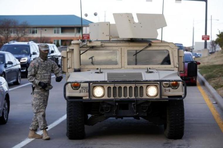 A National Guard walks by a Humvee in Clayton, Missouri, November 25, 2014.
