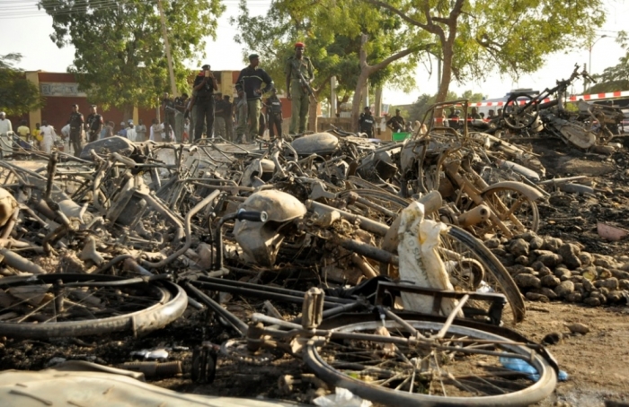 Police officers stand near wreckage at a scene of multiple bombings at Kano Central Mosque, November 28, 2014. Gunmen set off three bombs and opened fire on worshippers at the central mosque in north Nigeria's biggest city Kano, killing at least 35 people on Friday, witnesses and police said, in an attack that bore the hallmarks of Islamist Boko Haram militants.