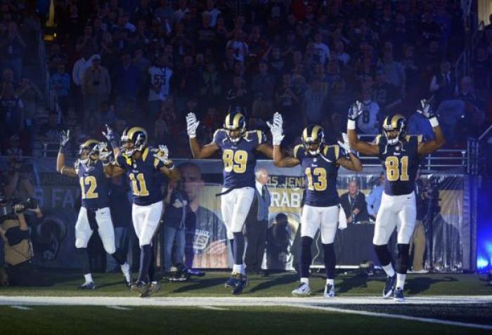 St. Louis Rams wide receiver Stedman Bailey (12) and wide receiver Tavon Austin (11) and tight end Jared Cook (89) and wide receiver Chris Givens (13) and wide receiver Kenny Britt (81) put their hands up to show support for Michael Brown before a game against the Oakland Raiders at the Edward Jones Dome.