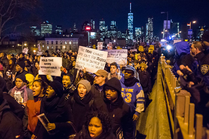 The Lower Manhattan skyline, including One World Trade Center, is seen in the background as protesters, demanding justice for Eric Garner, enter Brooklyn off the Brooklyn Bridge in New York December 4, 2014. Protesters swarmed streets of Manhattan and other cities for a second night of mostly peaceful rallies to denounce a New York grand jury's decision to spare a white police officer from criminal prosecution in the choking death of an unarmed black man. The reaction to Wednesday's decision not to indict officer Daniel Pantaleo for his role in the videotaped confrontation that left 43-year-old Eric Garner dead echoed a wave of outrage sparked nine days earlier by a similar outcome in the fatal shooting of an unarmed black teenager by a white policeman in Ferguson, Missouri.