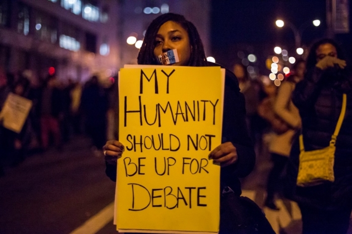 A female protester, demanding justice for Eric Garner, holds a placard in Brooklyn, New York, December 4, 2014. Protesters swarmed streets of Manhattan and other cities for a second night of mostly peaceful rallies to denounce a New York grand jury's decision to spare a white police officer from criminal prosecution in the choking death of an unarmed black man. The reaction to Wednesday's decision not to indict officer Daniel Pantaleo for his role in the videotaped confrontation that left 43-year-old Eric Garner dead.