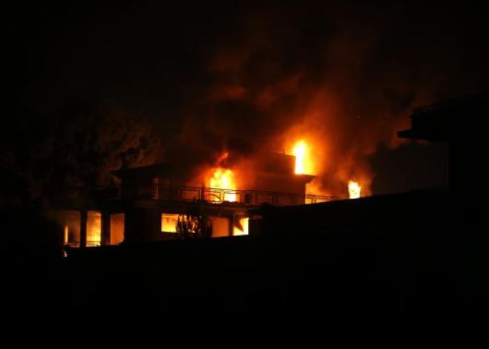 Fire eats away at a foreign aid workers' guest house after an attack by the Taliban in Kabul on November 29, 2014.